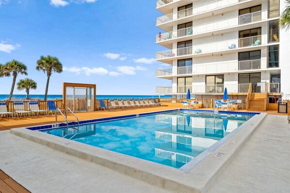 A pool area with lounge chairs and a view of the ocean. - Sweeping Gulf Views! 1/2 sleeps 4! (Panama City Beach)