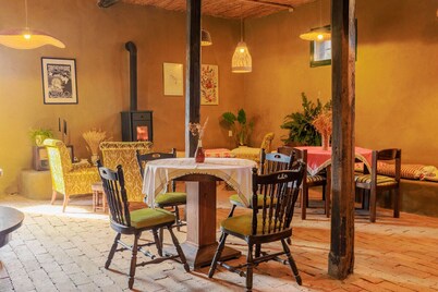 Cozy 3-bedroom farmhouse surrounded by a vibrant garden full of plants.