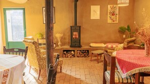 Uma sala de estar acolhedora com lareira, móveis estampados e uma porta verde.