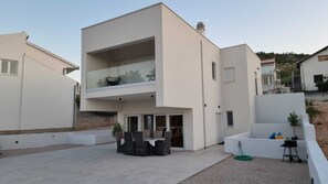 A modern two-story house with a balcony, a patio with outdoor furniture, and a small garden area. - 3-bedroom villa in Raslina with 3 air condition.
Near beach,Šibenik, Vodice... (Raslina)