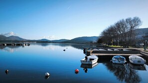 A calm lake with boats docked at the shore, surrounded by hills and clear skies. - 3-bedroom villa in Raslina with 3 air condition.
Near beach,Šibenik, Vodice... (Raslina)