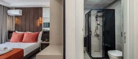 A modern hotel room with a bed, a bedside table, and a shower area with a glass door.