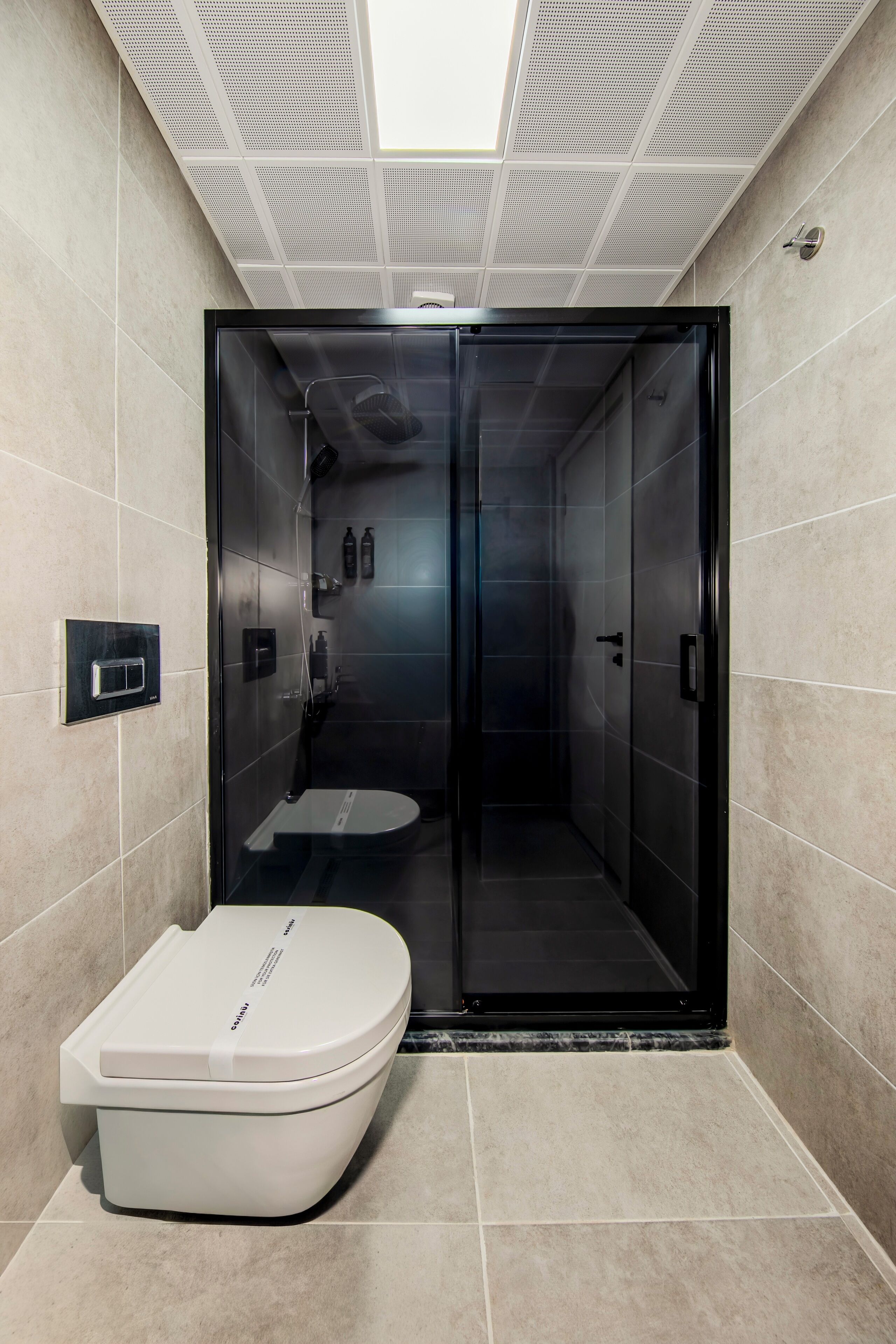 Ein modernes Badezimmer mit Toilette, Duschkabine und Glasduschtür.