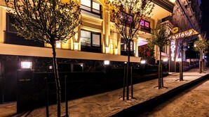 A hotel with a modern facade, illuminated windows, and a well-lit entrance area. - Cosinüs Airport Hotel (Arnavutköy)