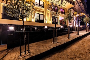 A hotel with a modern facade, illuminated windows, and a well-lit entrance area. - Cosinüs Airport Hotel (Arnavutköy)