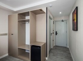 Un pasillo con un armario, una puerta y un pequeño electrodoméstico negro.
