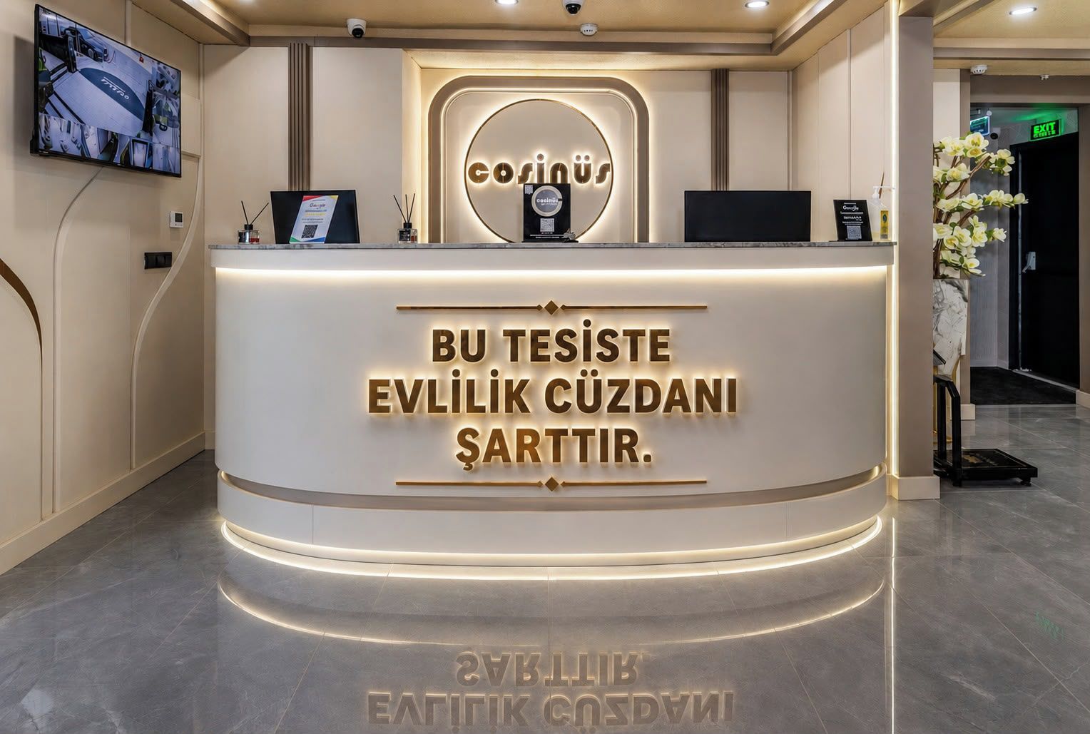 Un comptoir d’accueil au design moderne, un écran numérique et un panneau indiquant l’engagement de l’hôtel en faveur du développement durable et de la protection de l’environnement.