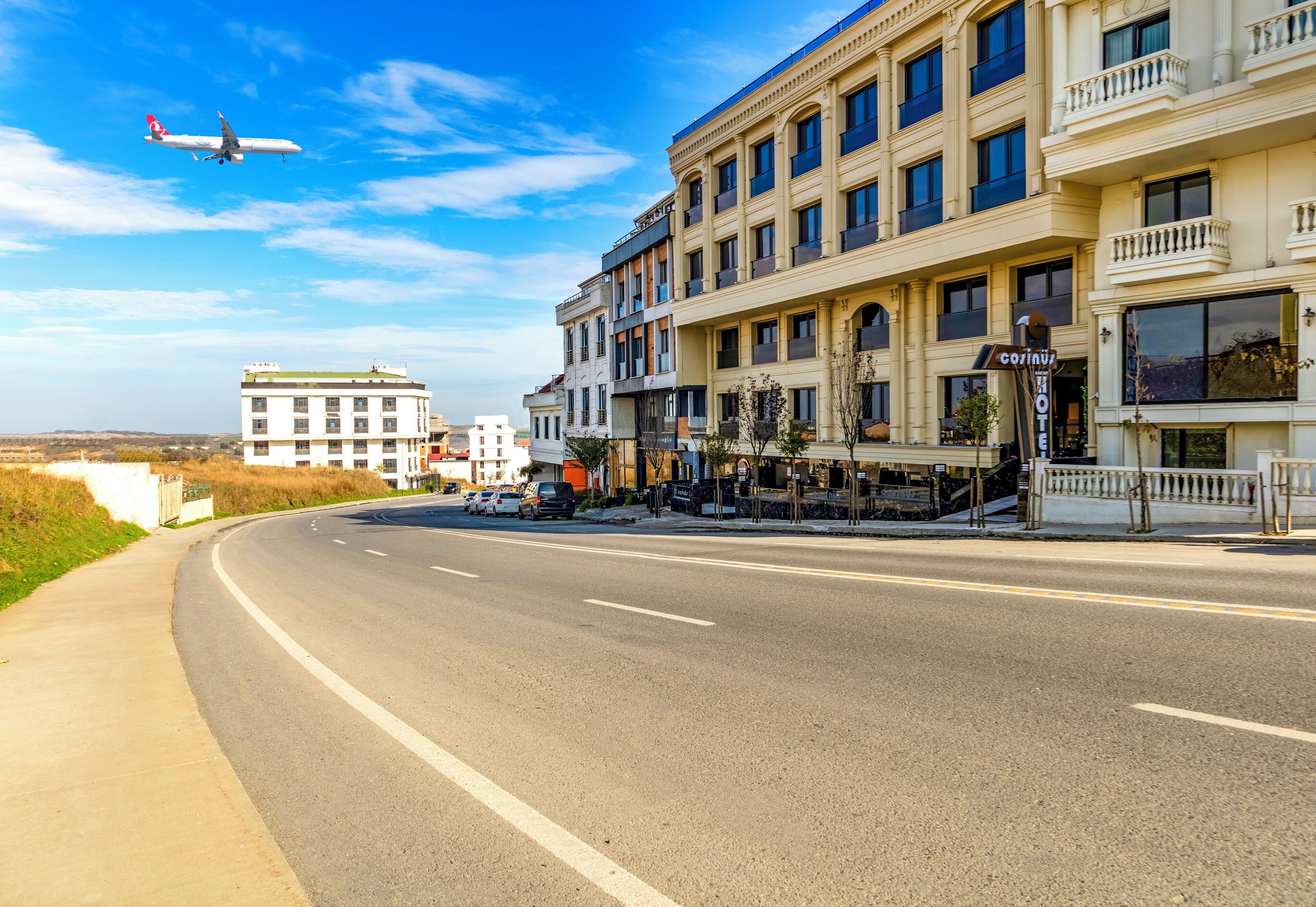 A hotel with a modern facade, multiple balconies, and a clear view of the street.