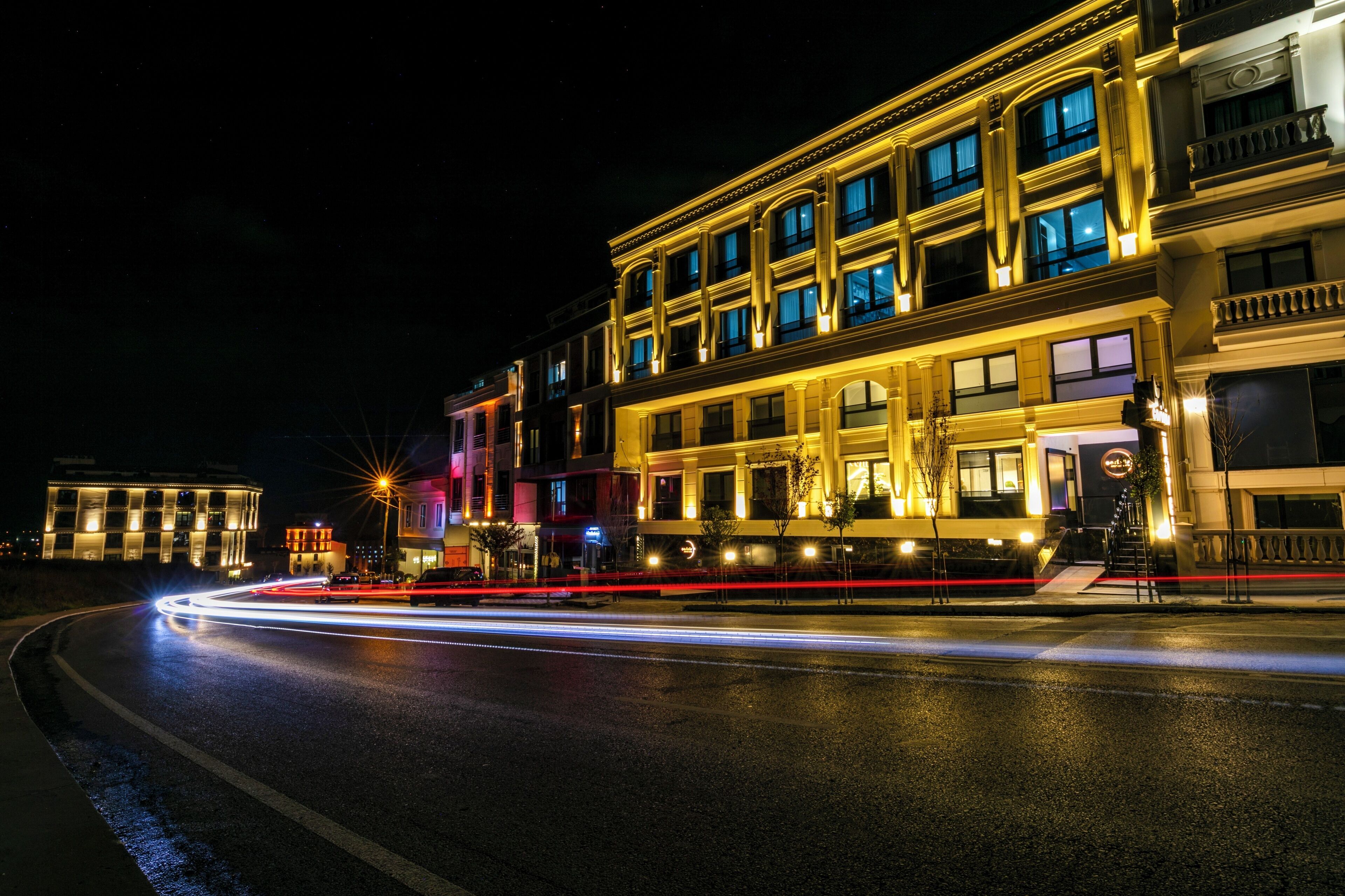 A multi-story building with illuminated windows and a well-lit entrance.