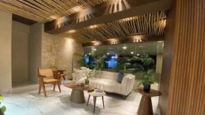 En moderne lobby med en hvid sofa, træstole og en marmorgulv.