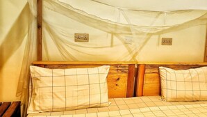 A bed with a wooden headboard, two pillows, and a canopy. - Lights of Kazinga Homestay (Kichwamba)