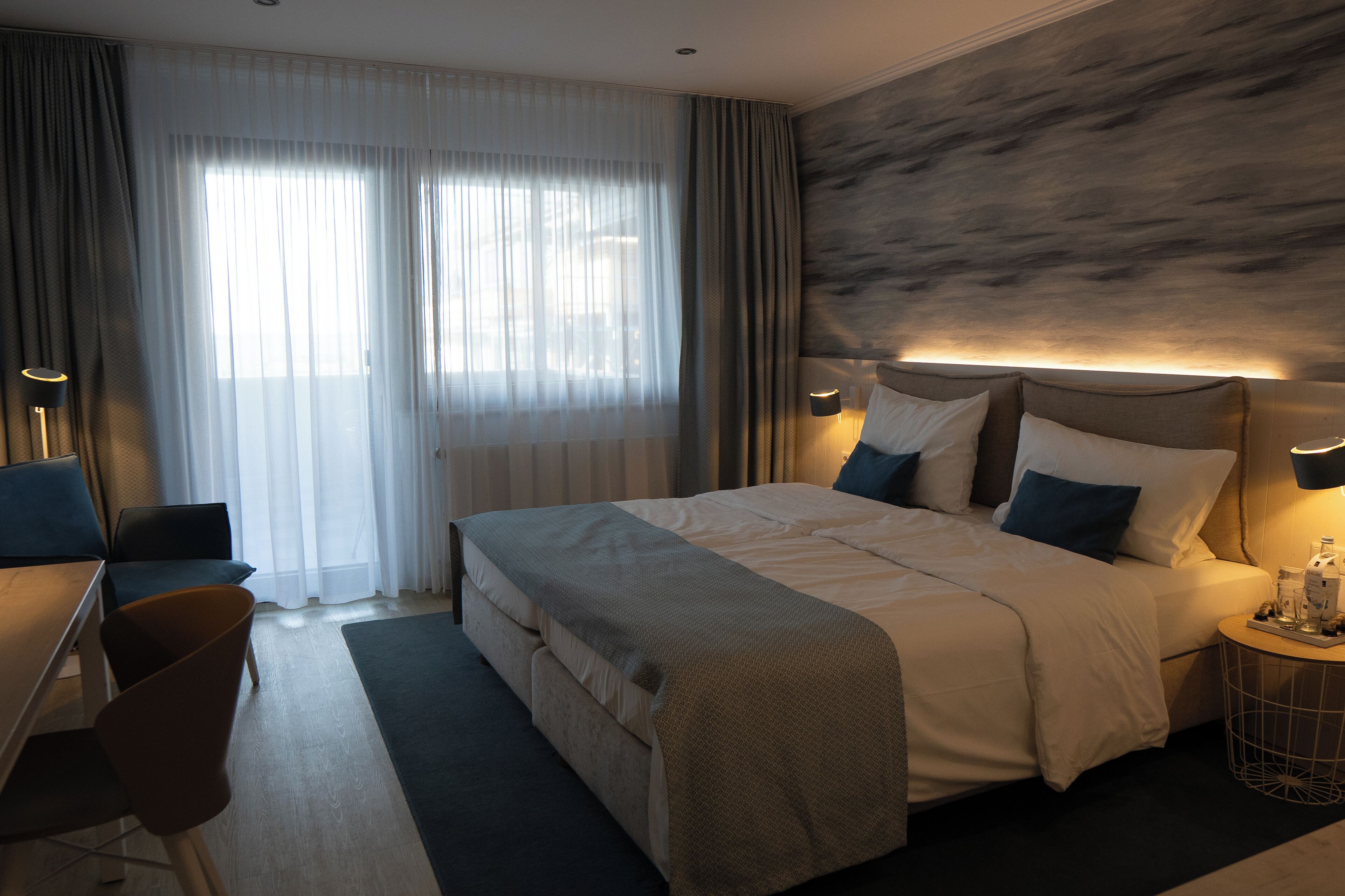 Une chambre d’hôtel avec un grand lit, un bureau et une chaise.