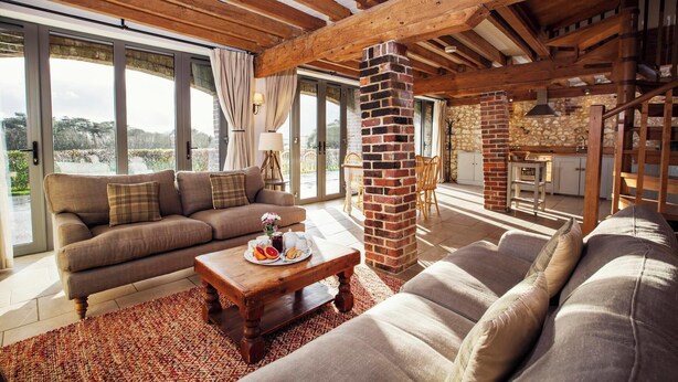A cozy living room with a fireplace, large windows, and a dining area.