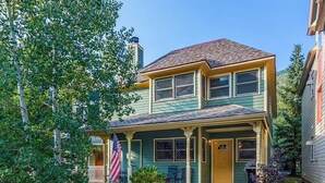Ein zweistöckiges Haus mit Veranda und einer amerikanischen Flagge.