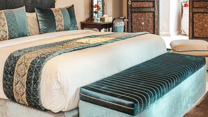 A bedroom with a large bed, a bench, a hanging light fixture, and an open door leading to a balcony. - Kasbah La Moun The Art of Hospitality (Marrakech)