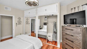 A bedroom with a bed, wardrobe, and a television on a dresser. - Comfort Meets Convenience – 3BR + Free Parking (Boston)