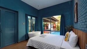 Un dormitorio con una cama grande, una bañera blanca y vistas a una piscina.