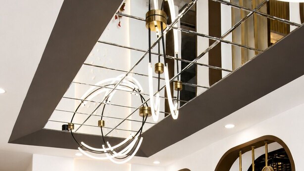 Un interno moderno con un motivo geometrico sul pavimento, un divano componibile, un tavolino rotondo e un lampadario originale.