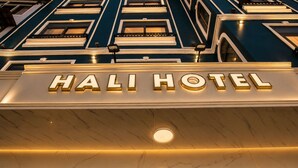 L'esterno dell'Hotel Hali con un cartello luminoso ben visibile.
