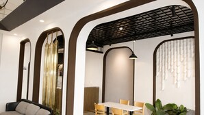 Un interno con zona pranzo, divano e soffitto a griglia.