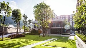 A modern building with a well-maintained lawn, a clear pathway, and a large tree in the center. - Valley Mountain View&City Proximity
 1 bedroom 1 living room 1kitchen 1 toilet (Phuket)