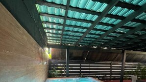 Een hottub onder een glazen dak, met houten wanden en stenen vloer.