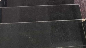 A staircase with dark tiles leading to a landing. - Kusum guest House  (Ayodhya)