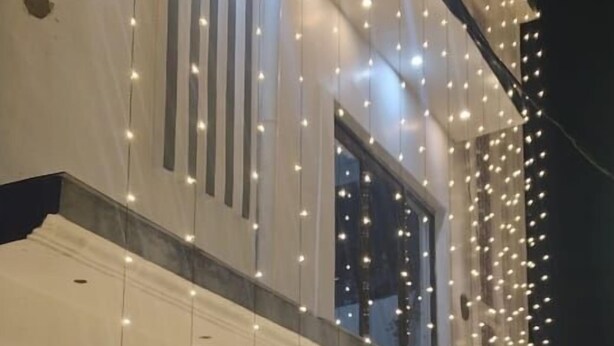 A building with a white facade, multiple windows, and a balcony. - Kusum guest House  (Ayodhya)