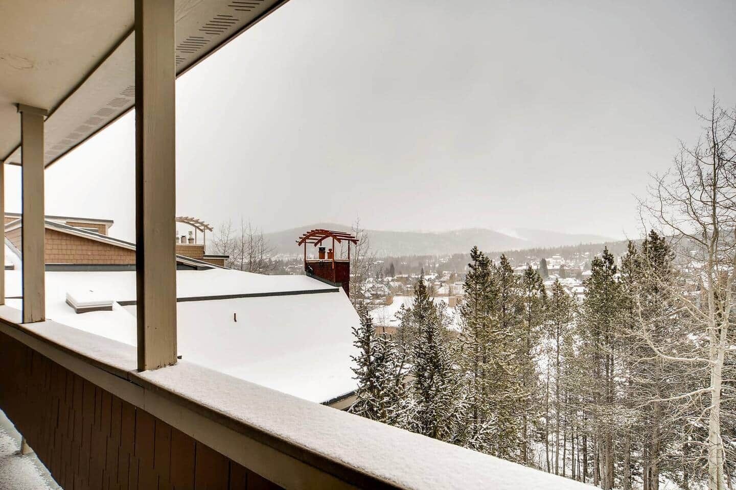 Blick aus einem Fenster auf eine verschneite Landschaft mit einer Seilbahn in der Ferne.