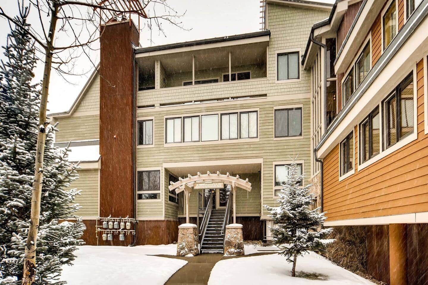 A multi-story building with a central entrance, a staircase, and a snow-covered landscape.