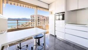 Une cuisine moderne dotée d’une grande fenêtre offrant une vue sur la côte.