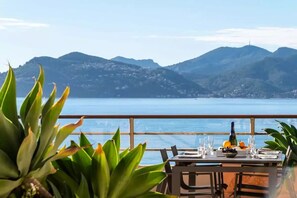 A table set for dining with a view of the sea and mountains in the background. - 3P Panoramic View & Beach Access   (Cannes)