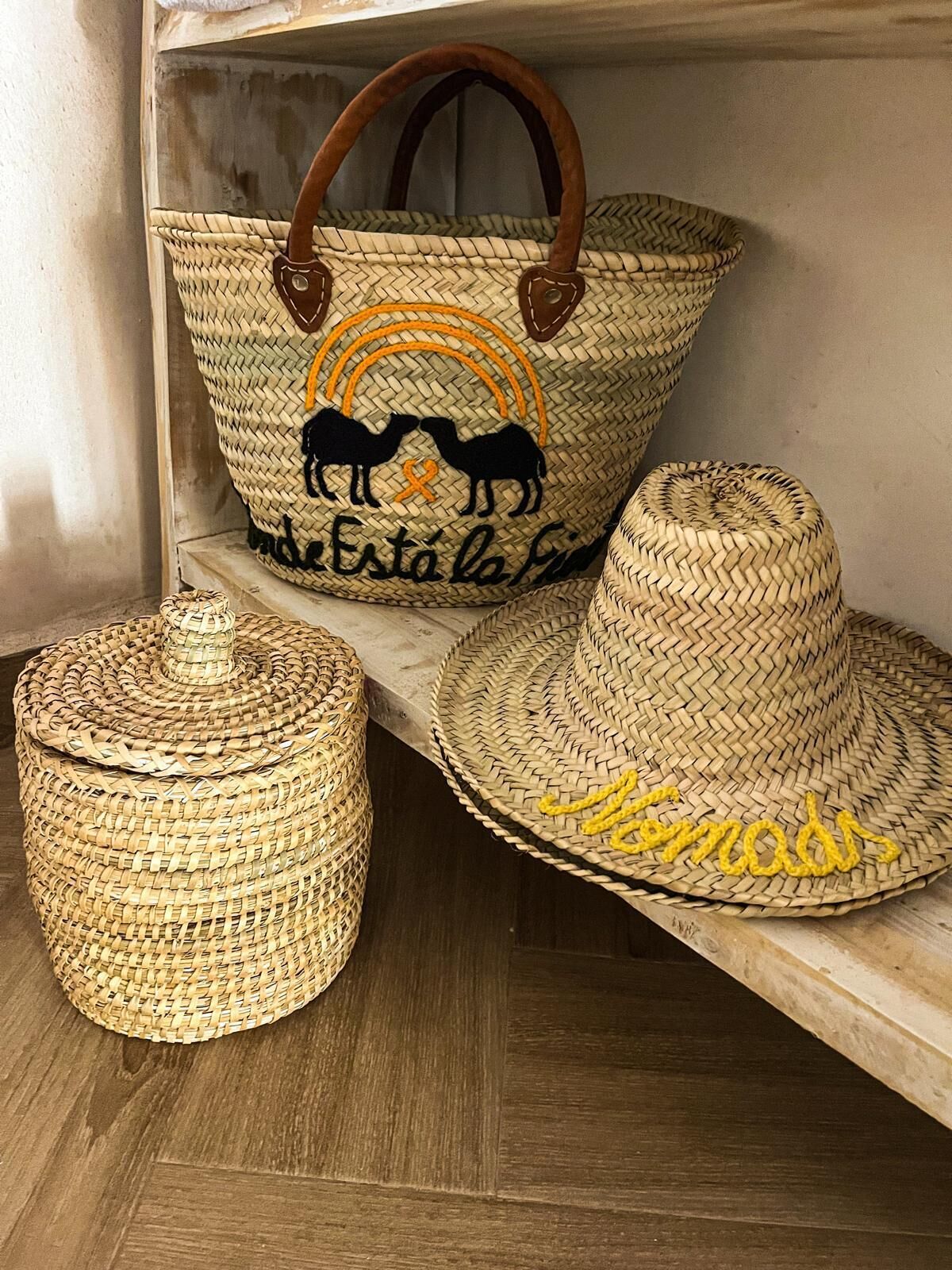 A woven basket with a handle, a woven container, and a woven hat with a yellow design.