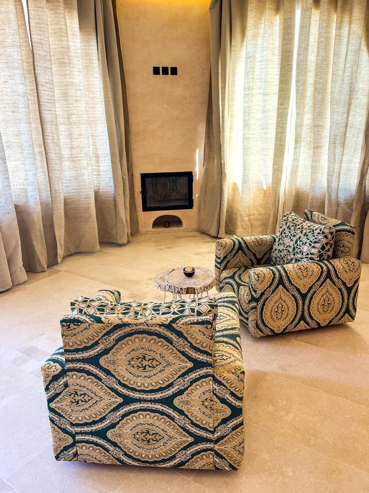 A living room with a sofa and armchair, a small table, and a fireplace.