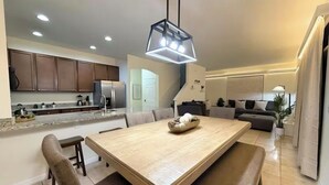 A modern kitchen with dark wooden cabinets, a granite countertop, and a built-in oven. - Family Home 20 min Disney - 4BR - Heated Pool - BBQ (Kissimmee)