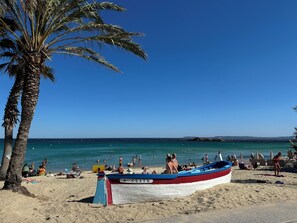 A beach with a boat named 'S'CLAIR' and palm trees. - Vacation Home in Bormes-les-Mimosas - Southern France (Bormes-les-Mimosas)