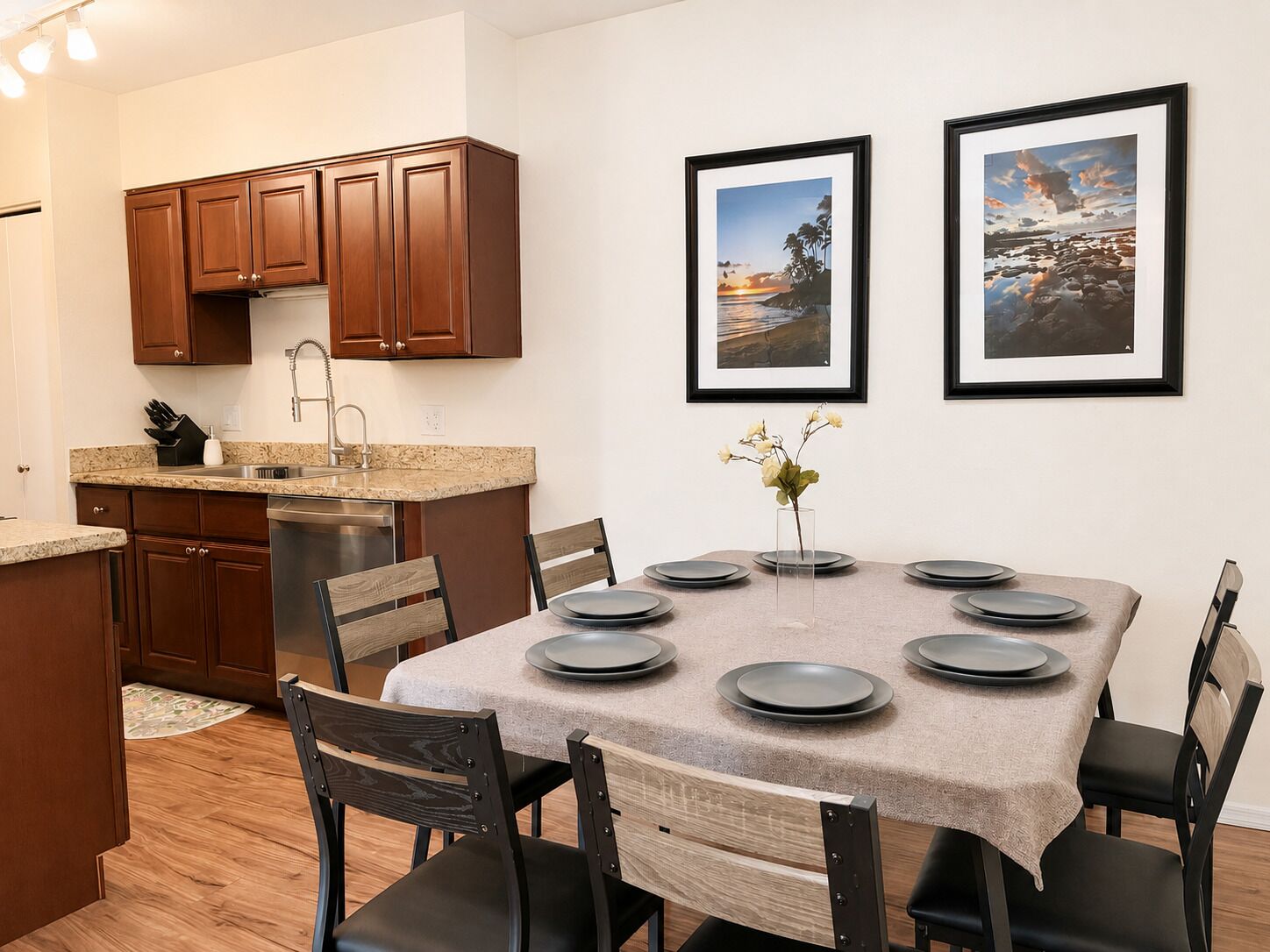 A modern kitchen with wooden cabinets, a stainless steel dishwasher, and a granite countertop.