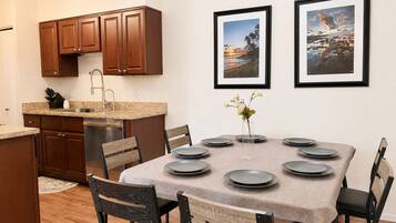 A modern kitchen with wooden cabinets, a stainless steel dishwasher, and a granite countertop.