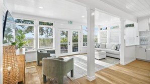Un interior moderno con una zona de estar, una cocina y ventanas amplias.
