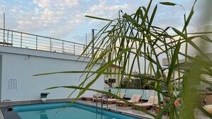 Una piscina con sillas de descanso y una barandilla.