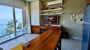 Eine moderne Küche mit Esstisch aus Holz, integrierten Schränken und einem großen Fenster mit Blick auf eine schöne Landschaft.