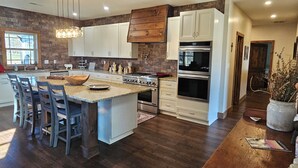 Una cocina moderna con una isla central, armarios de madera y un horno grande.