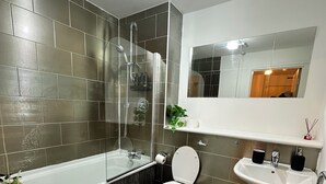 Un bagno moderno con vasca, WC, lavandino e doccia.