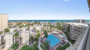 A resort with multiple buildings, a central swimming pool, and a view of the ocean. - Where the Sky Meets the Sea – Luxury Dream Views (South Padre Island)