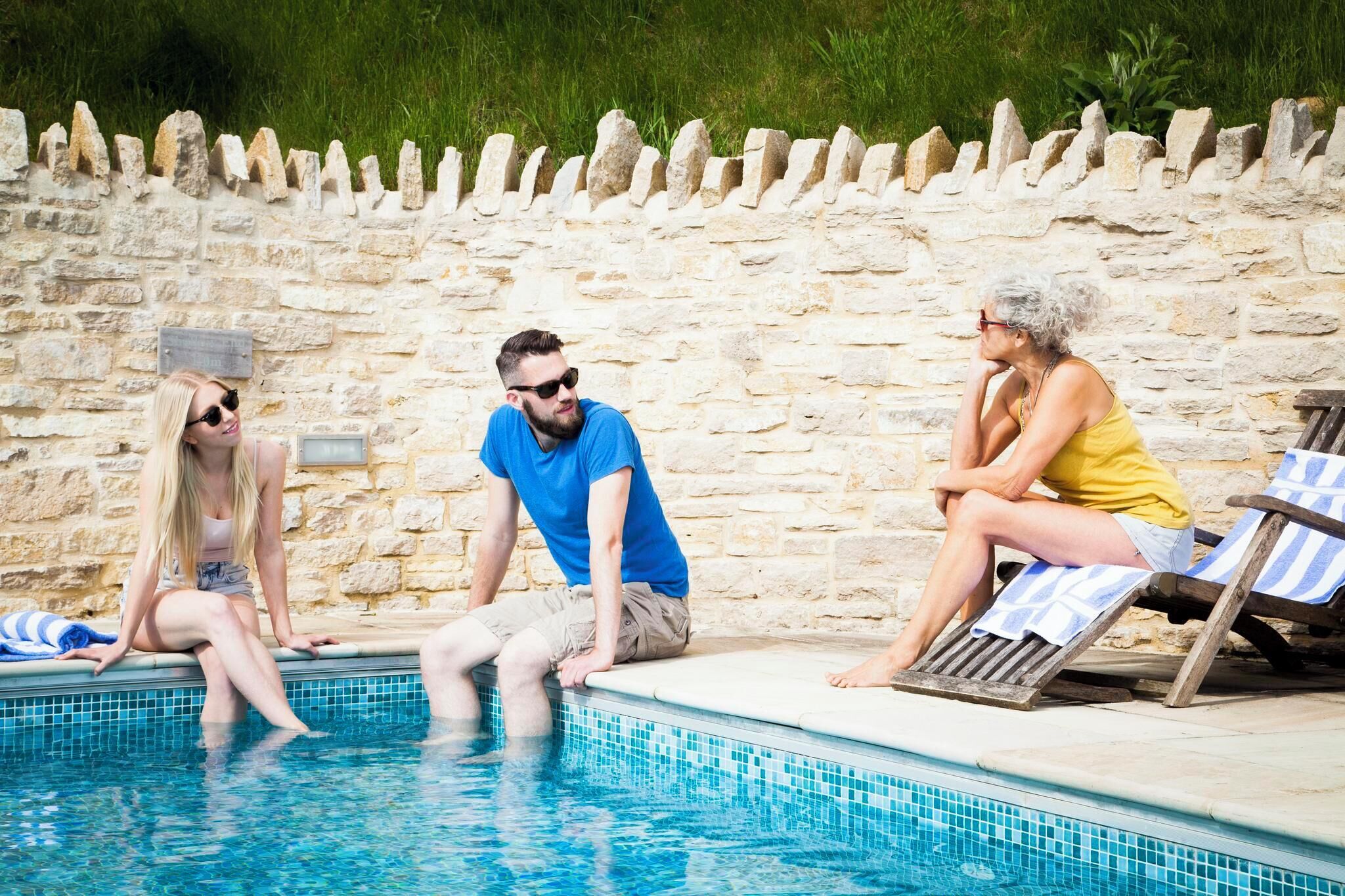 Un mur de pierre avec une zone piscine carrelée.