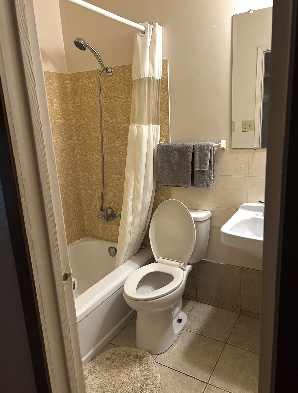 A bathroom with a bathtub, toilet, and sink.