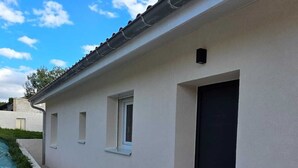 Un bâtiment moderne doté d’un toit plat, d’une petite fenêtre et d’une porte.