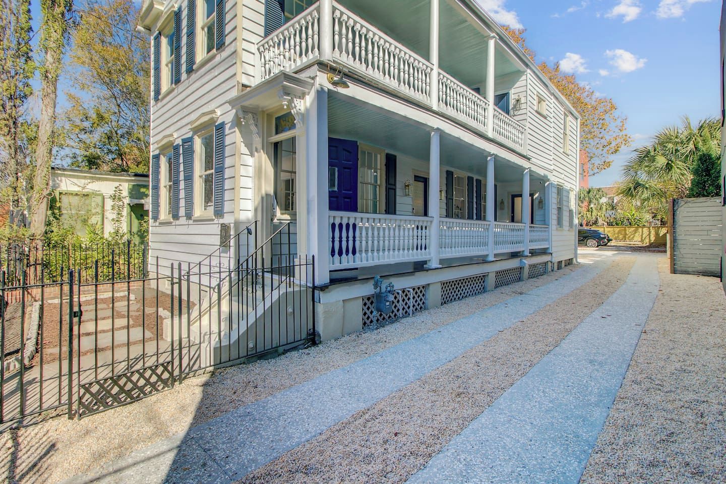 A two-story house with a covered porch and a fenced yard.