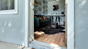 A modern home entrance with a sliding door leading to a living room, a kitchen area, and a dining space. - NEW WeHo Hotspot | 8 min Broadway, DTN + Music Row (Nashville)