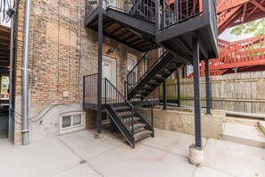 Un edificio de ladrillo con una escalera de metal que lleva a un balcón.